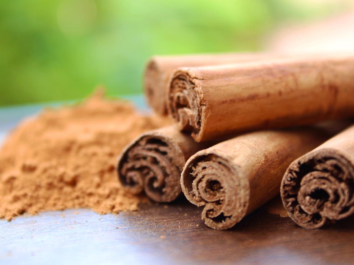 Cinnamon sticks on a table next to ground cinnamon