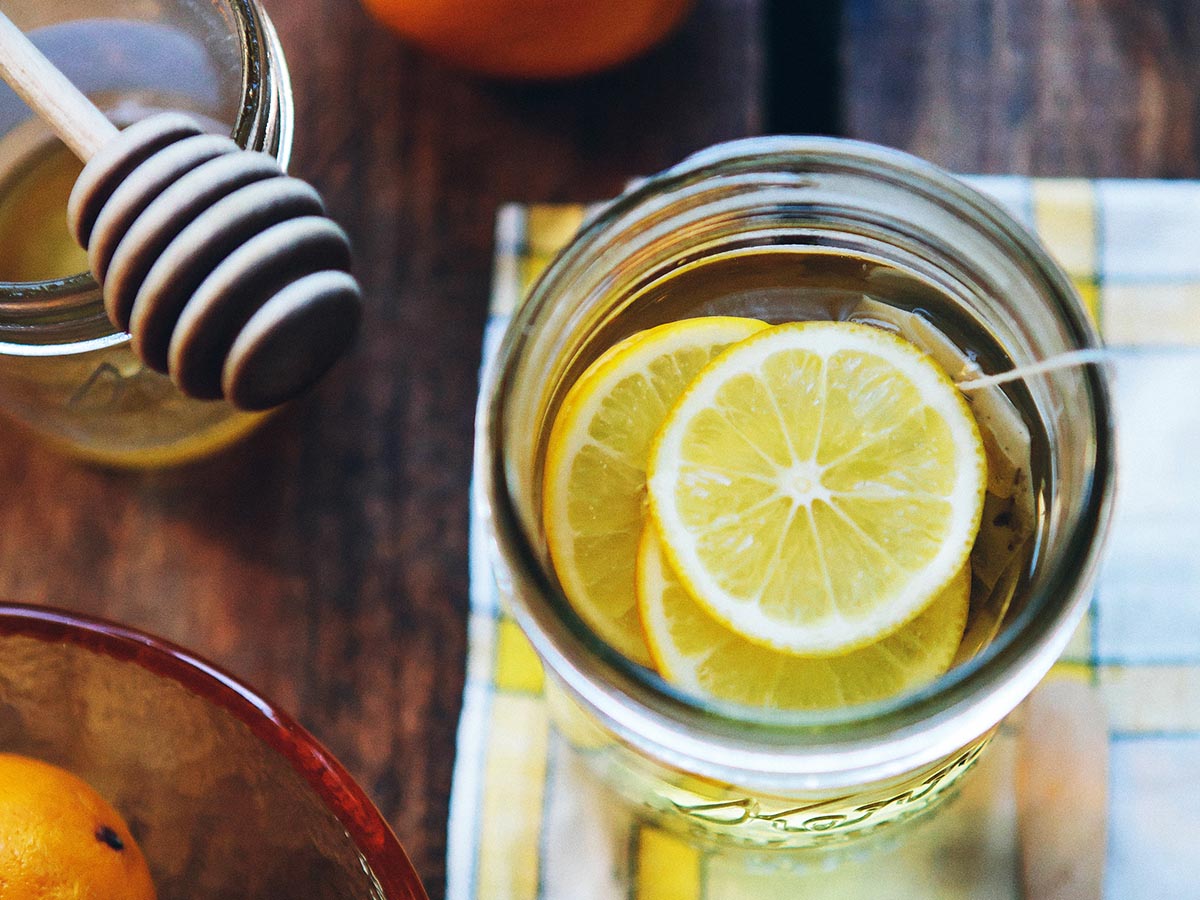 Glass of water with honey, cinnamon and lemon in it